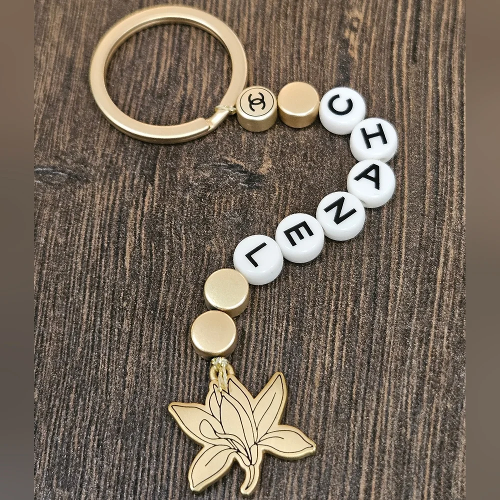 NIB CHANEL Sublimage Gold & White Beaded Keychain with Flower Charm
